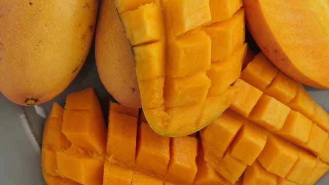 Yellow ripe cut mango on plate, Rotate