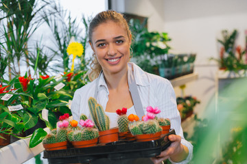 woman holding decorative cactuses