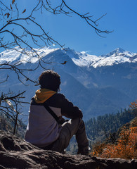 lonely man staring snow covered mountains 
