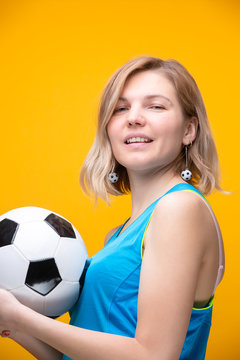 Photo of blonde with soccer ball on yellow background