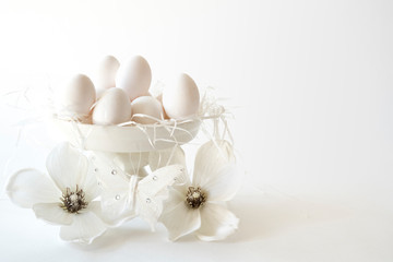 Fototapeta na wymiar white romantic Easter scene, cake stand with eggs and flowers, against white background, space for text