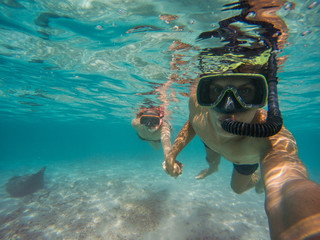 Selfie of young couple snorkeling in the sea.
