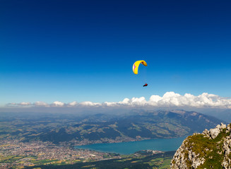 Fototapeta na wymiar Paroplan flies over the city of Thun and the lake from the mountain of Nizen