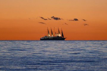 Fototapeta na wymiar Segelschiff am Horizont bei Sonnenuntergang