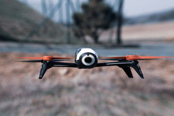Flying drone with mounted camera outdoor.