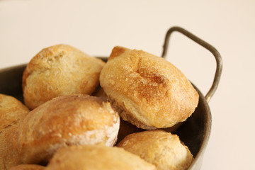 Just baked sourdough homemade buns with seeds lying in old antique metal basket