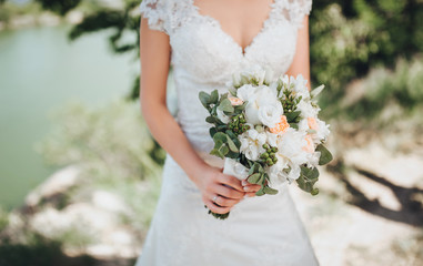 Wedding bouquet in bride's hands. White and pink roses.