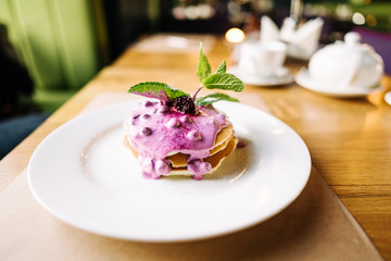 stack of pancakes with jam on white plate with ornate