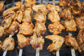 Roasted chicken wings kebab on skewers, close-up, outdoors. 