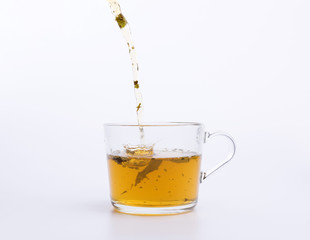 Green tea pouring in the cup isolated on white background