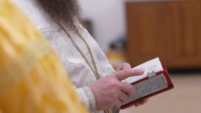glans in Orthodox chirch. Bible of a priest hands