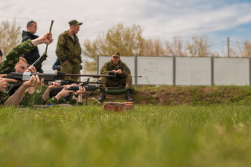 The soldiers lie on the ground and aim at the target. Army exercises.