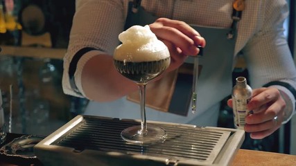 Barman is making cocktail at night club. Unique man.