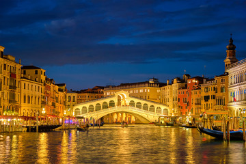 Fototapeta na wymiar Rialto bridge Ponte di Rialto over Grand Canal at night in Venice, Italy