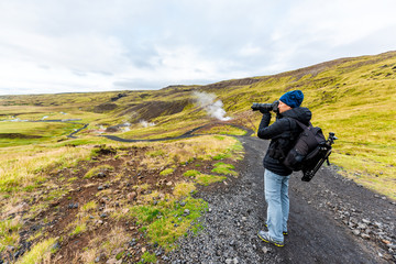 Reykjadalur, Iceland Hveragerdi Hot Springs road footpath with steam landscape morning in golden circle with man and camera tripod on hiking trail - Powered by Adobe