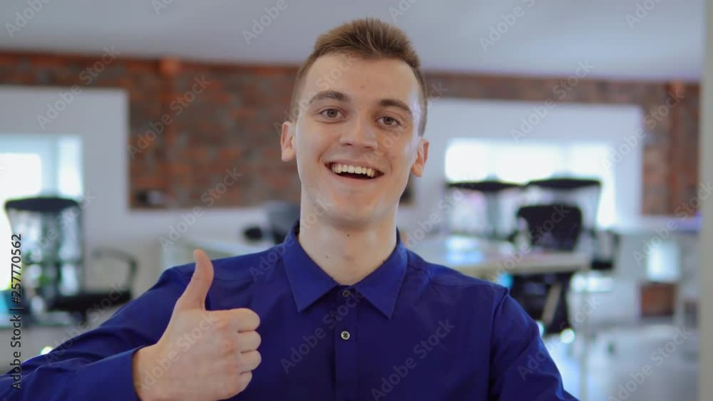 Aufkleber cheerful employee laughing showing hand gesture thumb up looking at the camera front view. portrait 