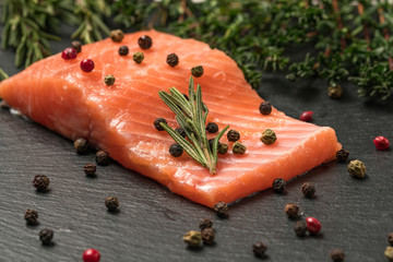 Raw salmon, trout fillet on a dark slate background. Wild atlantic fish. Healthy food.