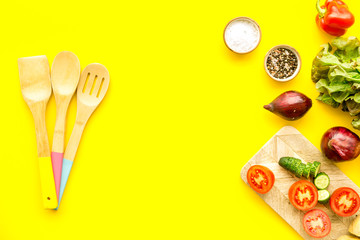 cooking with raw vegetables on yellow background top view