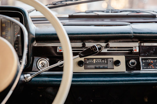 Retro styled image of an old car radio and dashboard inside a classic car