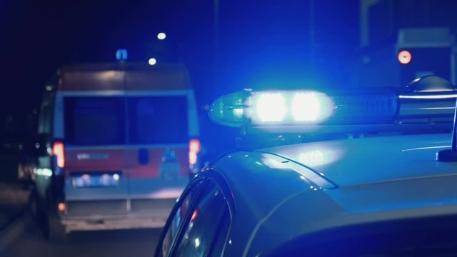 An accident on the highway in a major resort town. A team of ambulance paramedics and a fire truck rescue people. 911. Bright lights, flashing lights and sirens of a police patrol car. Car Crash