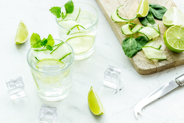 fresh drink with lime, cucumber and ice on white background