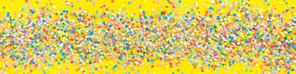 Fototapeta na wymiar Frame made of colored confetti. Yellow background