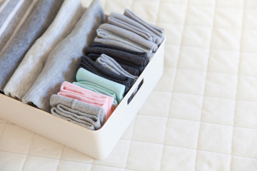 Basket or box with neatly folded colorful socks. Socks or clothes organization and sorting method.