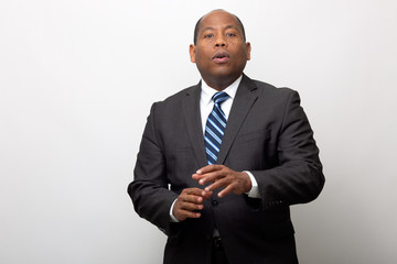 Business Man Making Hand Gesture on Plain Light Gray Background