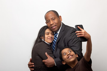 Mixed Raced Couple Posing for Photo and Son Taking Selfie with Smart Phone