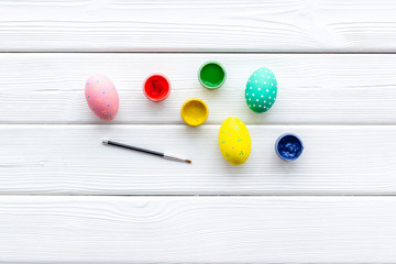eggs with colorful paint for easter tradition on white wooden background top view mockup