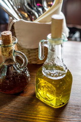 bottle of olive oil and olives on wooden table