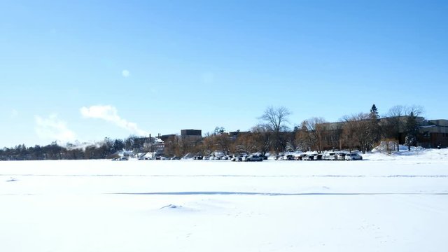 Cars parked on frozen Lake Bemidji near the University where students have a shorter walk to class on a sunny winter day.