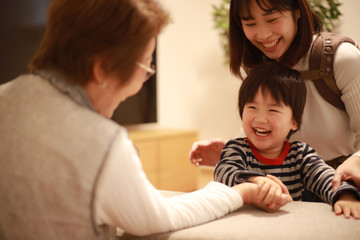 腕相撲をする男の子とシニア女性