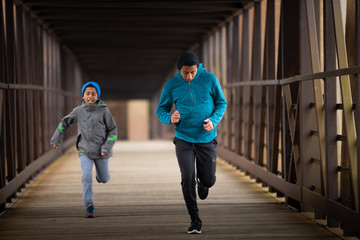 Obraz premium Two Hispanic Brothers Run A Race Down Bridge