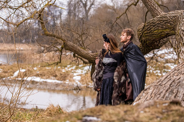 Cosplay Ideas. Young Couple Posing as Prince and Princess on Ancient Closing in Spring Forest.