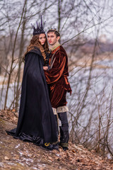 Caucasian Couple as King and Queen in Fur Medieval Outfit With Crowns Posing Together Outdoor.