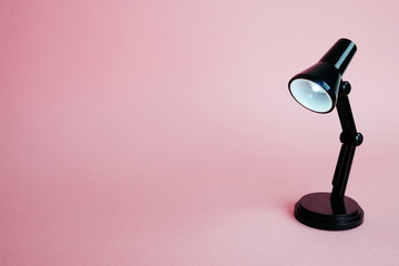 Black desk lamp isolated on pink background