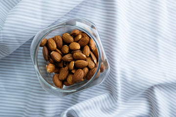 Almond in a glass bottle on tablecloth