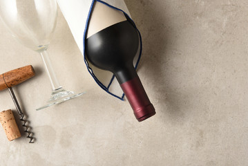 High angle view of a Cabernet Sauvignon wine bottle wrapped in a towel  with wineglass and corkscrew