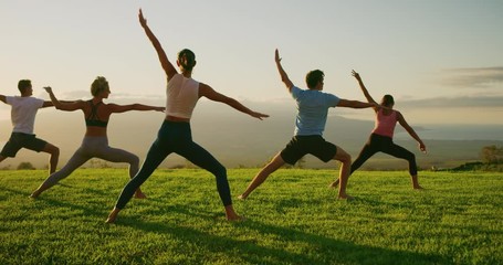 Yoga class at sunset, happy diverse group of young people practicing yoga poses together, stretching health and wellness - Powered by Adobe