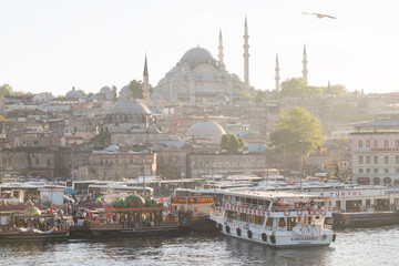Naklejka premium Istanbul, Turkey - 04 22 2016: Floating restaurants and the New Mosque Yeni Cami in Eminonu. View from Galata Bridge, Golden Horn, Istanbul, Turkey