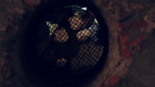 Young people talking through the bars. Prison, museum, quest. Exploring the history, castle, curiosity. True friends, fun, adventure time. Hanging out, traveling.