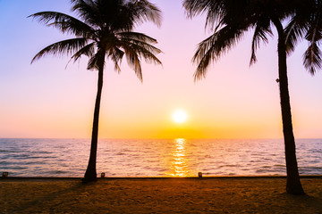 Obraz na płótnie Canvas Beautiful Silhouette coconut palm tree on sky neary sea ocean beach at sunset or sunrise time