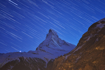Beautiful star trails over the famous mountain Matterhorn at night in winter, Zermatt, Switzerland.
