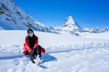 Fototapeta na wymiar Young Woman Tourists playing snow in mountain Matterhorn peak, Zermatt, Switzerland.