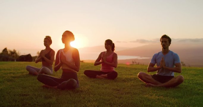 Zen meditation practice at sunset, group of diverse young people meditating together at sunset, zen health and wellness