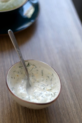 Small bowl of dill and lemon flavored yoghurt sauce. Selective focus.