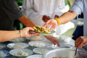 The hands of the rich are giving food to the poor and hungry.