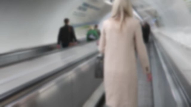 Blurred London underground commuters walking along a moving walkway (travelator)