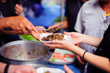 Food donation: The hands of the hungry are receiving food from the service provider.